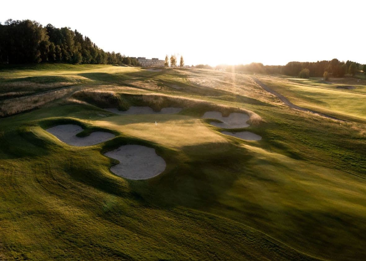 Solnedgang over bunkere og fairway på Miklagard Golf